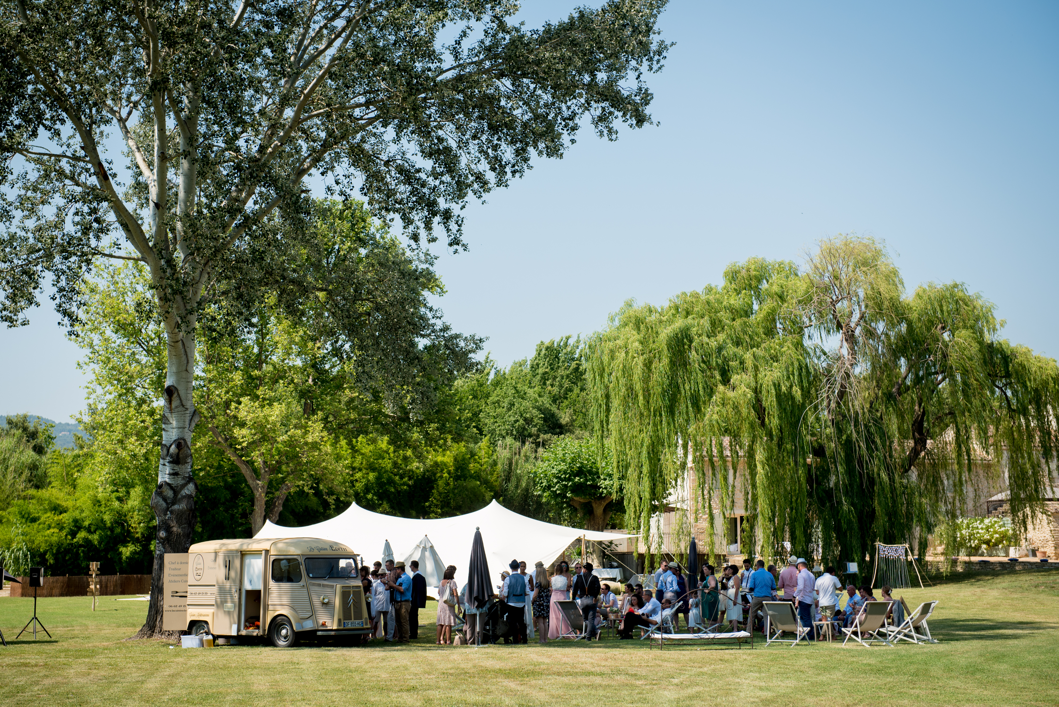 Installation de cérémonie de mariage en extérieur, sous les arbres avec chaises blanches – lieu de réception champêtre proposé par L’effet Maria