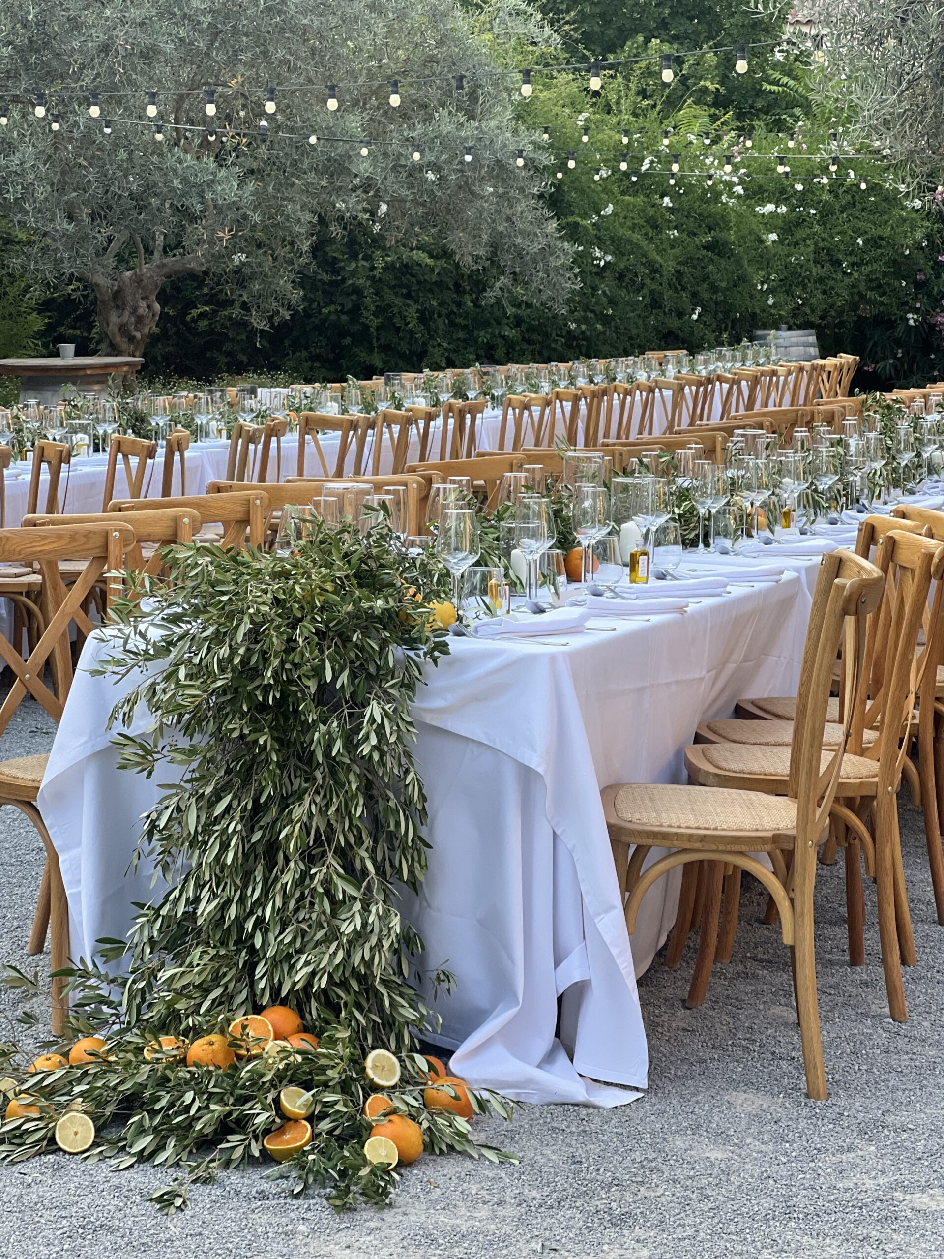 Grande table de réception en extérieur décorée de fleurs et feuillage, pour un mariage champêtre chic organisé par L’effet Maria
